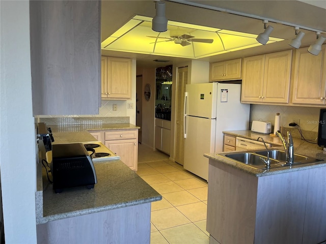 kitchen featuring ceiling fan, light tile patterned flooring, light brown cabinets, a sink, and freestanding refrigerator