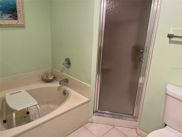 full bath with a bath, a stall shower, toilet, and tile patterned floors