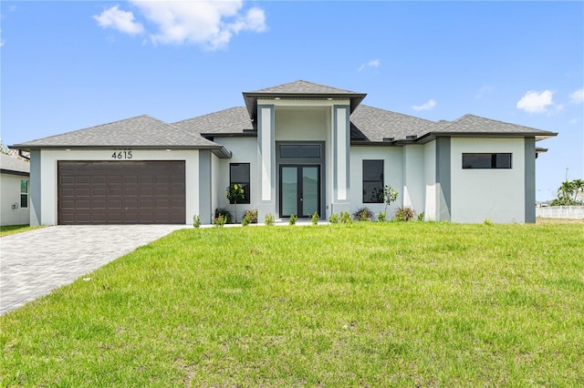 prairie-style home with decorative driveway, roof with shingles, stucco siding, a front yard, and a garage