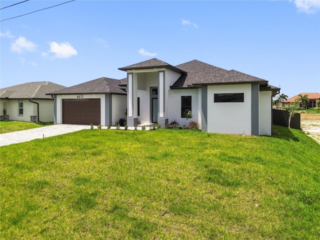 prairie-style house featuring an attached garage, stucco siding, decorative driveway, and a front yard