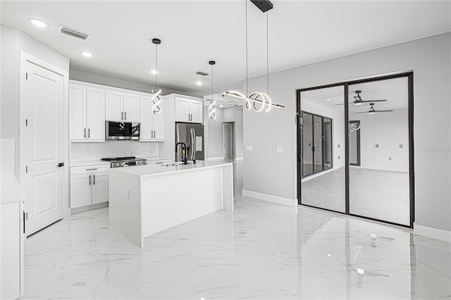 kitchen with stainless steel appliances, light countertops, decorative light fixtures, and white cabinetry