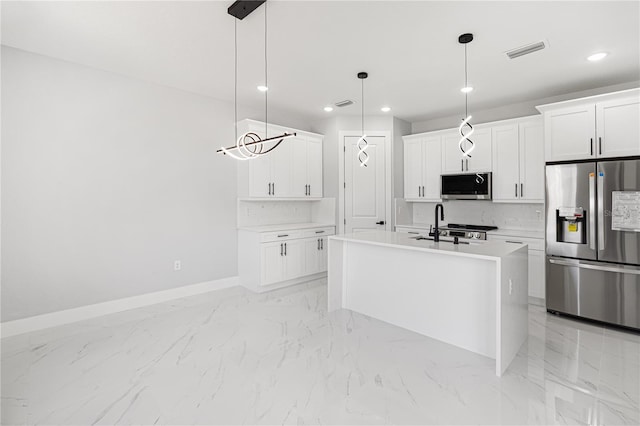 kitchen with visible vents, hanging light fixtures, appliances with stainless steel finishes, light countertops, and an island with sink