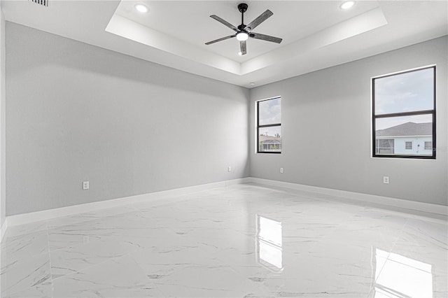 spare room featuring ceiling fan, recessed lighting, a raised ceiling, and baseboards