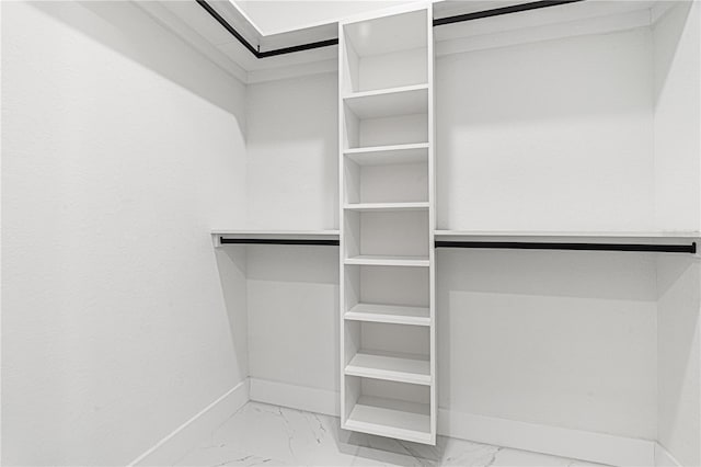 walk in closet featuring marble finish floor