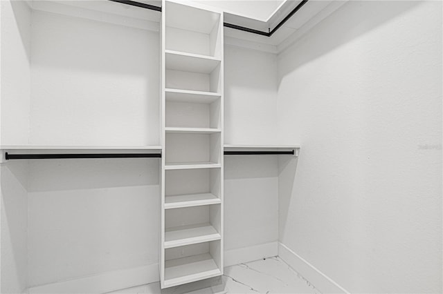 walk in closet with marble finish floor