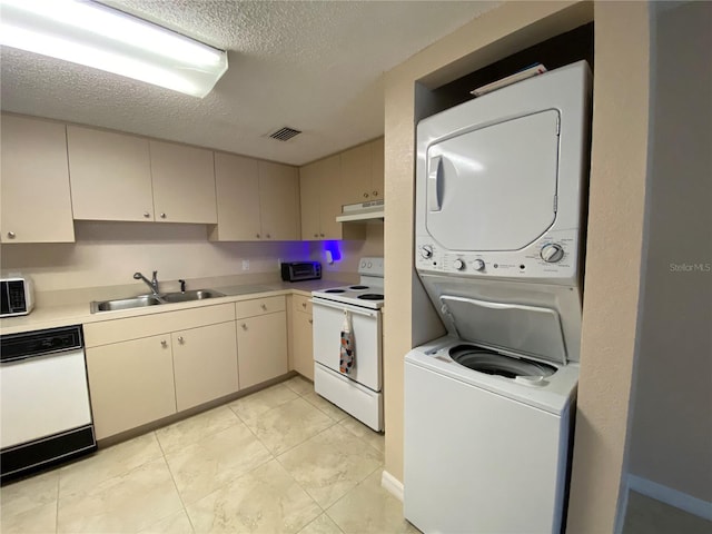 kitchen with light tile patterned flooring, stacked washer and clothes dryer, sink, a textured ceiling, and white appliances