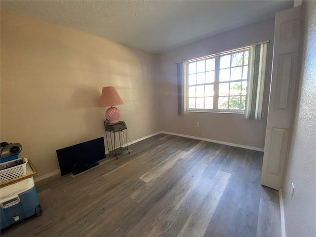 empty room featuring dark wood-type flooring and a textured ceiling