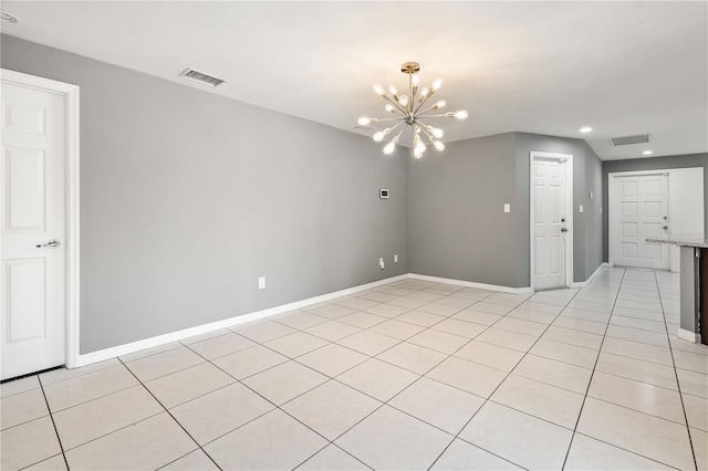 spare room featuring light tile patterned floors, visible vents, baseboards, and an inviting chandelier