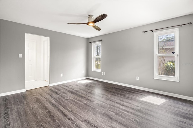 unfurnished room featuring ceiling fan, baseboards, and dark wood finished floors