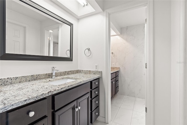 bathroom with marble finish floor and vanity