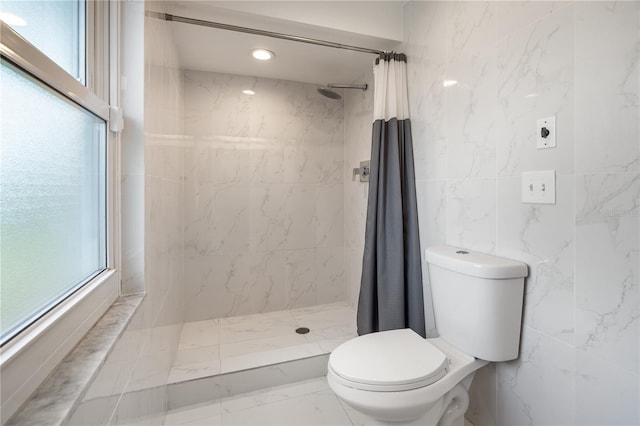 full bathroom featuring plenty of natural light, a shower stall, and marble finish floor