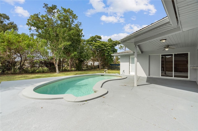 pool with a ceiling fan, a patio area, and a yard