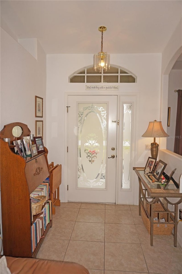 entrance foyer featuring light tile patterned flooring and a notable chandelier