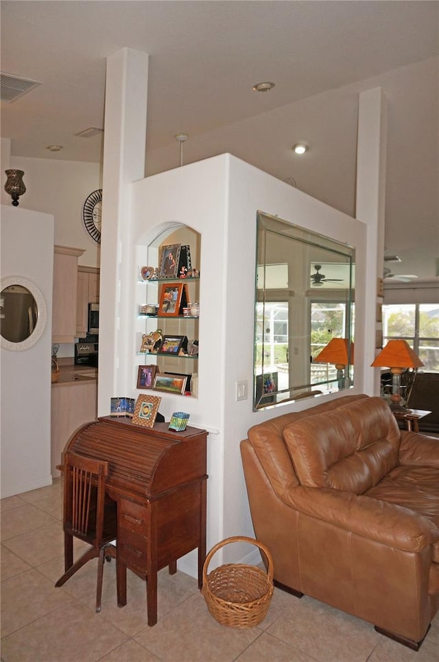 living room with built in features, a healthy amount of sunlight, and light tile patterned flooring