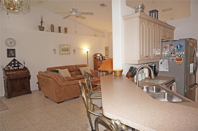 interior space featuring lofted ceiling, sink, stainless steel fridge with ice dispenser, light brown cabinets, and ceiling fan