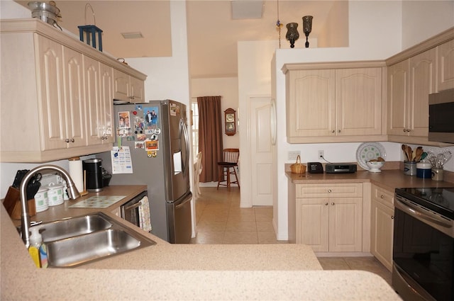 kitchen with stainless steel appliances, light tile patterned flooring, sink, and light brown cabinetry