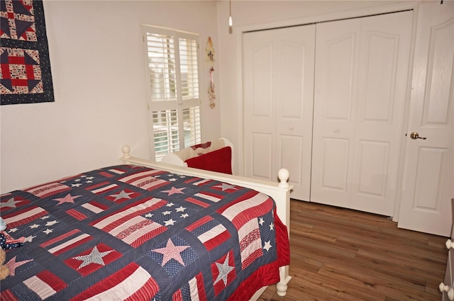 bedroom with dark hardwood / wood-style flooring and a closet