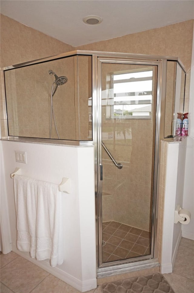 bathroom with tile patterned flooring, lofted ceiling, and an enclosed shower