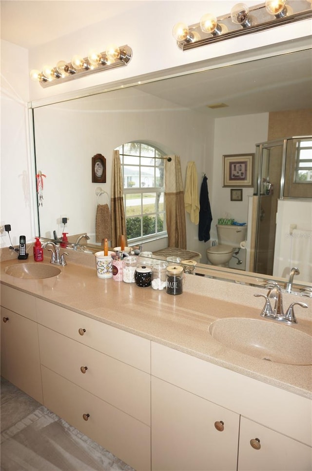 bathroom featuring vanity, toilet, a shower with shower door, and tile patterned flooring