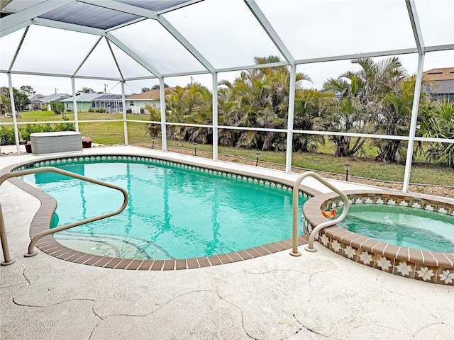 view of pool featuring a jacuzzi, a patio area, and a lanai