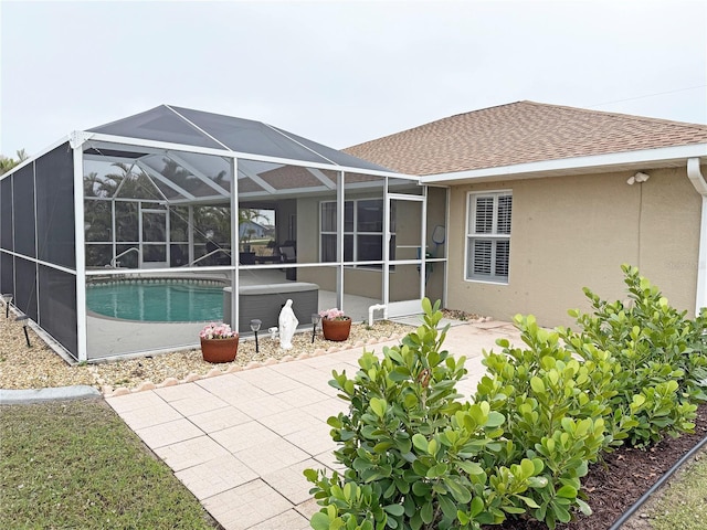 back of house featuring a patio and glass enclosure