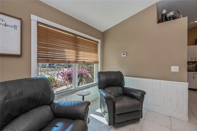 living area with lofted ceiling and light tile patterned flooring