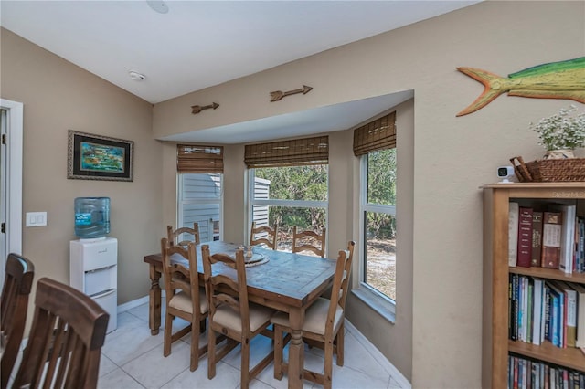 dining space featuring lofted ceiling and light tile patterned floors