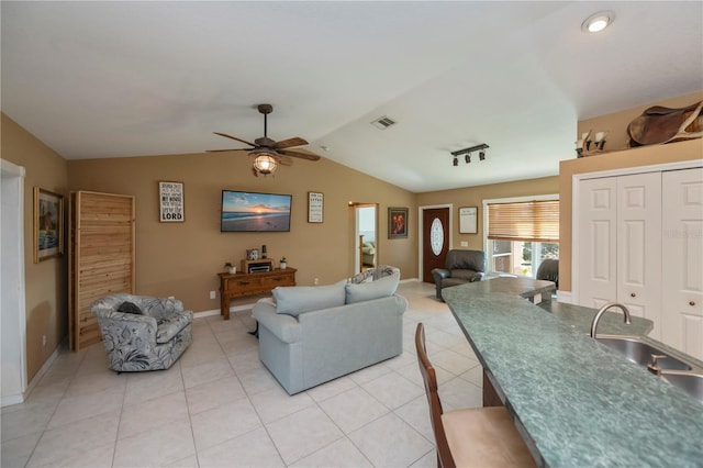 living room with sink, vaulted ceiling, ceiling fan, and light tile patterned flooring