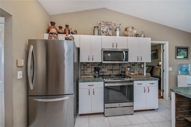 kitchen featuring white cabinetry, appliances with stainless steel finishes, vaulted ceiling, and tasteful backsplash