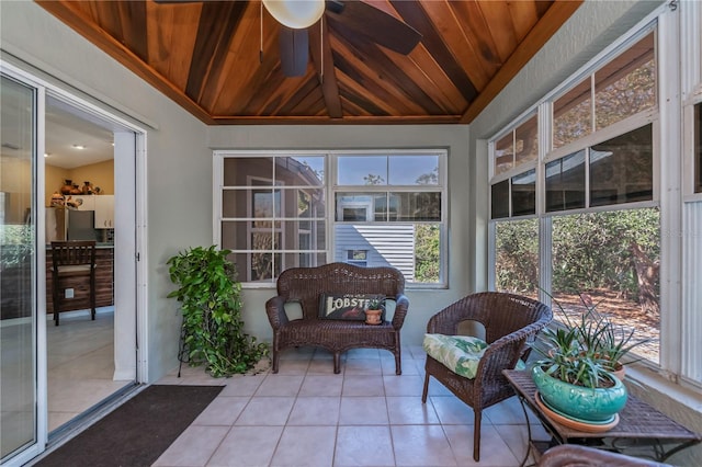 sunroom / solarium featuring vaulted ceiling, ceiling fan, and wood ceiling