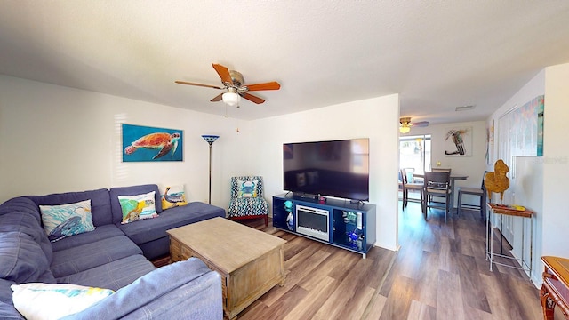 living room featuring wood-type flooring and ceiling fan