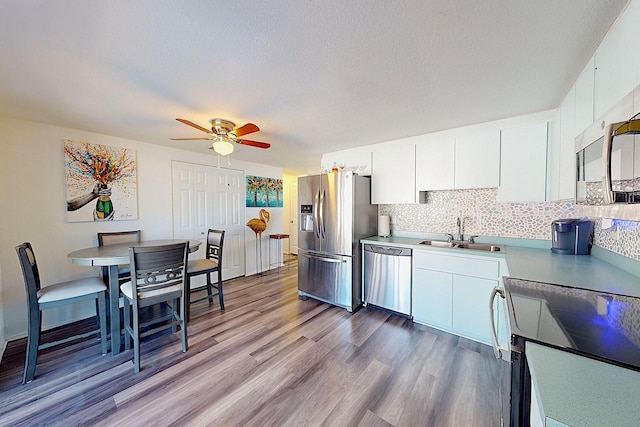 kitchen featuring white cabinetry, appliances with stainless steel finishes, sink, and light hardwood / wood-style floors