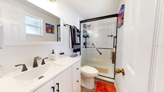 bathroom with vanity, toilet, and a shower with door