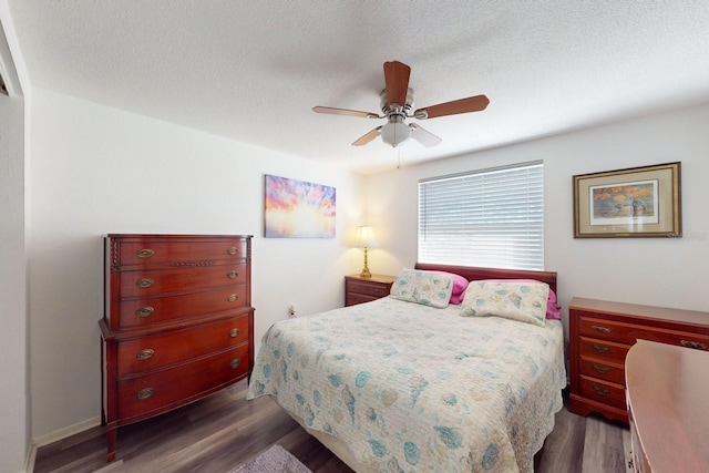 bedroom with dark wood-type flooring, a textured ceiling, and ceiling fan