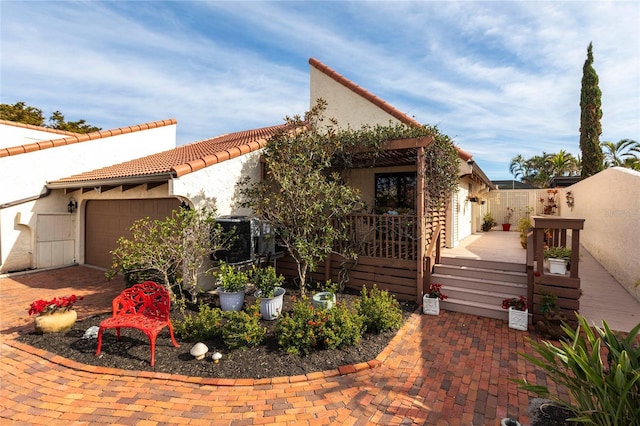 mediterranean / spanish house featuring a garage and a wooden deck