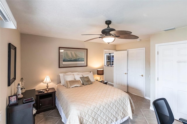 tiled bedroom featuring ceiling fan