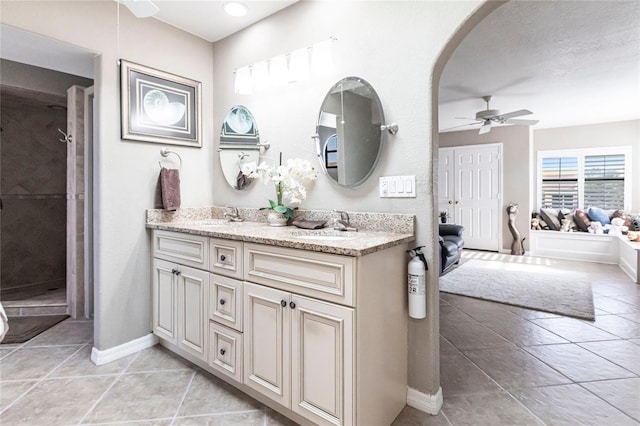 bathroom featuring tile patterned flooring, vanity, ceiling fan, and walk in shower