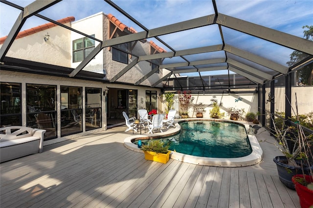 view of pool featuring a deck and glass enclosure