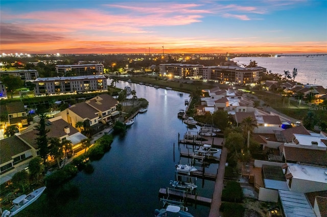 aerial view at dusk featuring a water view