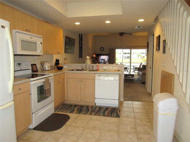 kitchen with white appliances, light brown cabinetry, kitchen peninsula, and sink