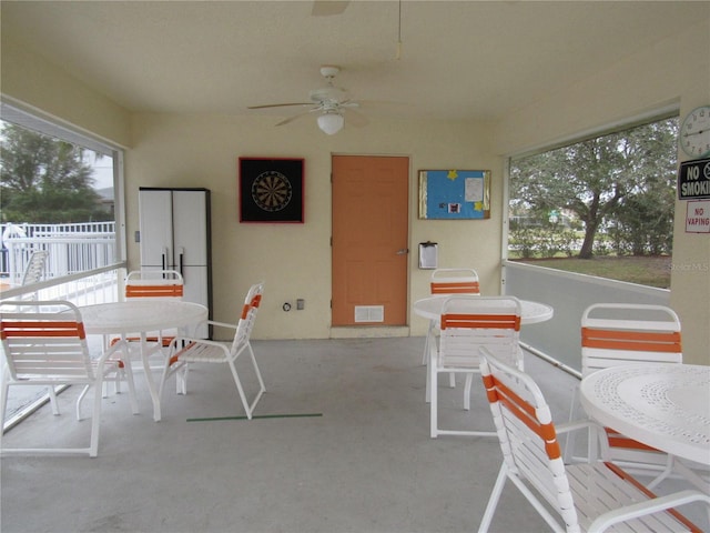 sunroom / solarium featuring ceiling fan