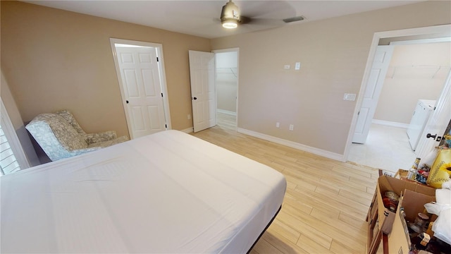 bedroom with ceiling fan, a spacious closet, a closet, and light wood-type flooring