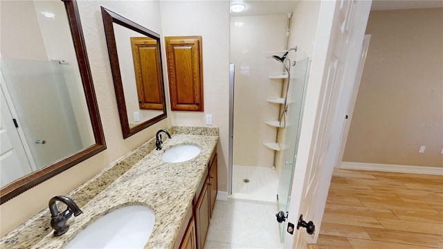 bathroom featuring hardwood / wood-style flooring, vanity, and tiled shower