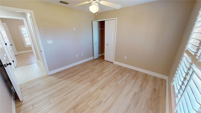 unfurnished bedroom featuring a closet, ceiling fan, and light wood-type flooring