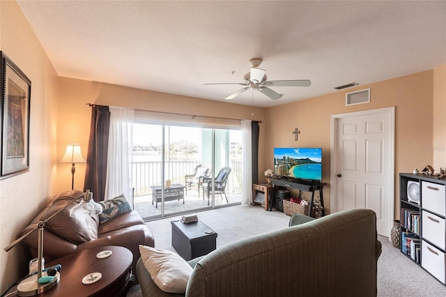 carpeted living room with ceiling fan