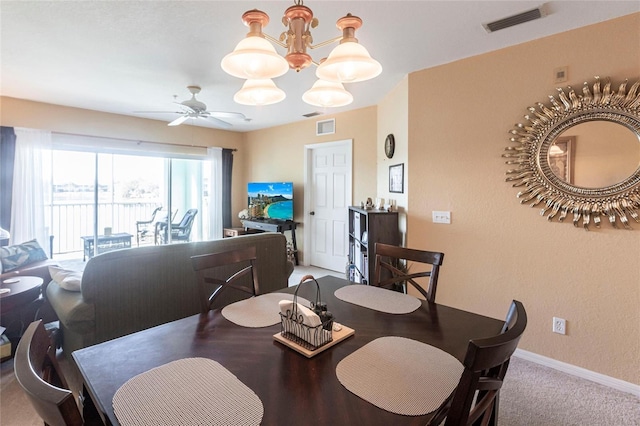 dining area with ceiling fan with notable chandelier and carpet floors