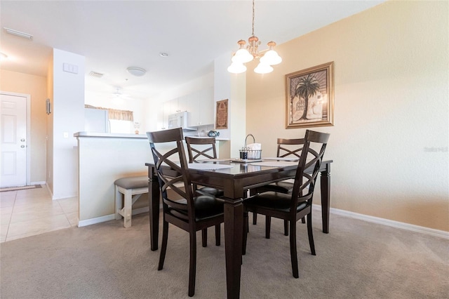 carpeted dining room featuring an inviting chandelier