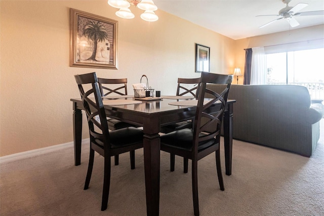 dining space featuring carpet floors and ceiling fan with notable chandelier