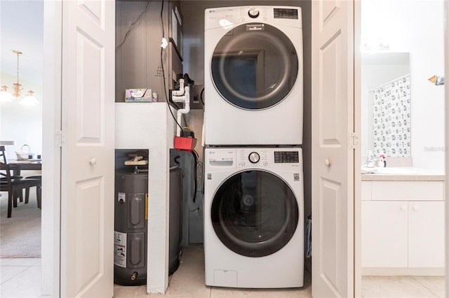 washroom featuring light tile patterned flooring, stacked washing maching and dryer, a chandelier, and sink