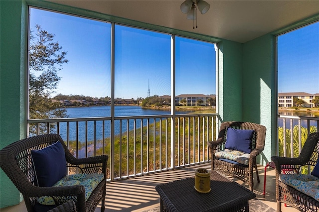 sunroom featuring a wealth of natural light and a water view